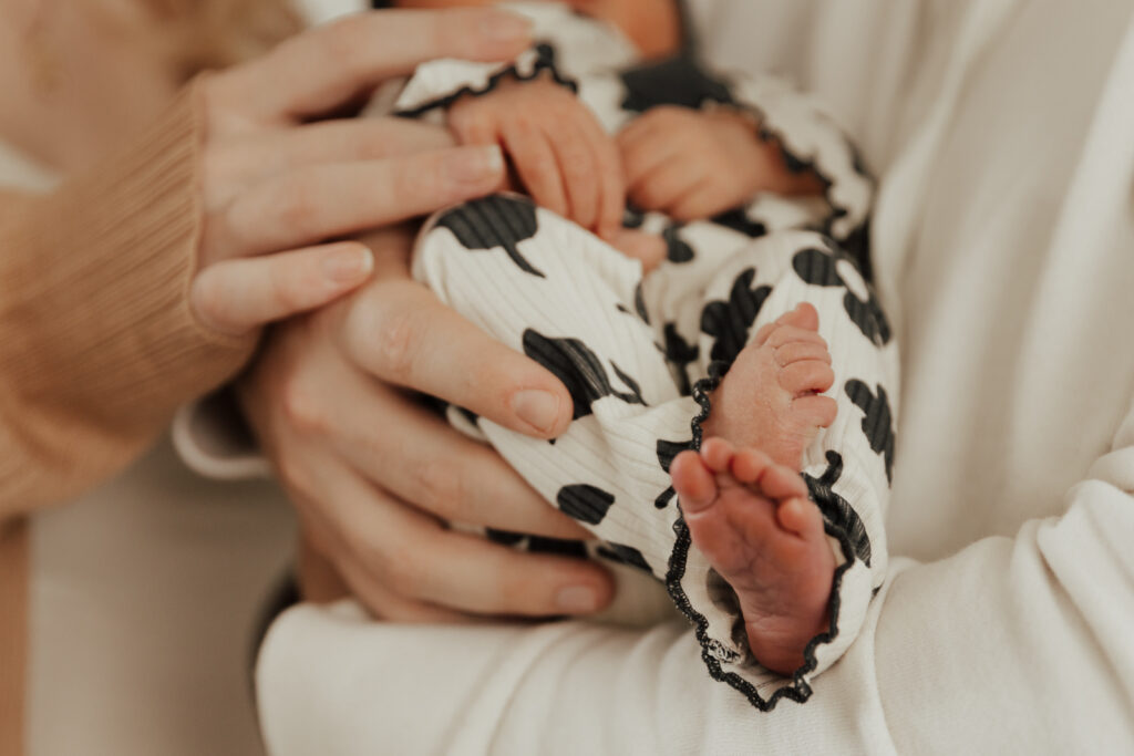 Details of a newborn baby&rsquo;s feet in an indoor studio wearing. Photography by Hannah Lylene Photography.