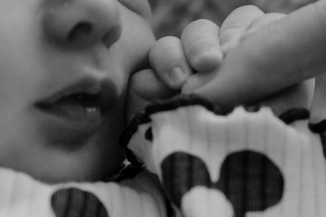 Details of a newborn baby’s lips and hands while being held by their parents. Photography by Dallas Photographer Hannah Lylene Photography