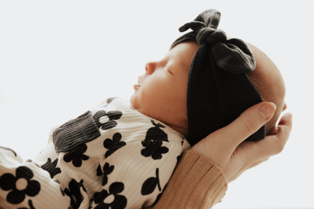 Details of a newborn baby’s face while being held by their parents. Photography by Dallas Photographer Hannah Lylene Photography