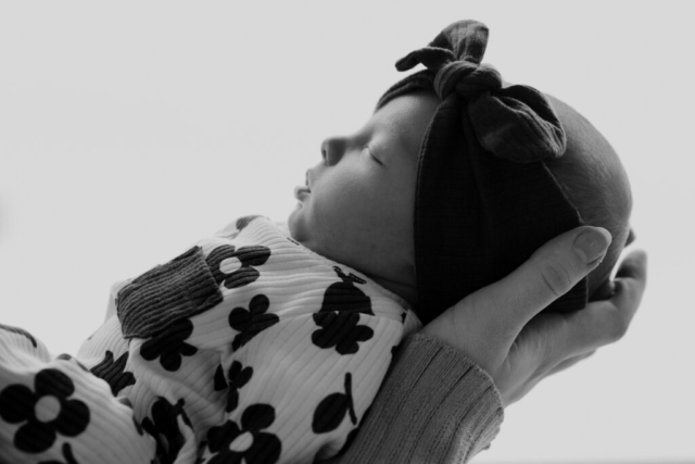 Details of a newborn baby’s face while being held by their parents. Photography by Dallas Photographer Hannah Lylene Photography