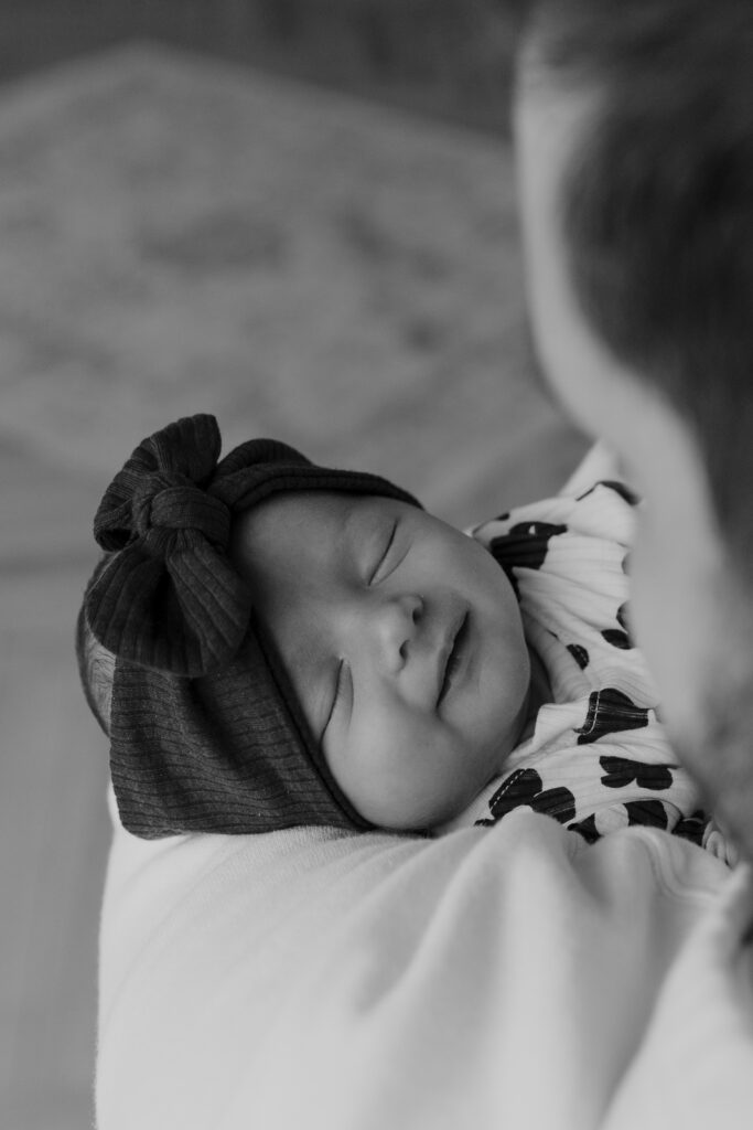 Details of a newborn baby&rsquo;s smile while being held by their parents. Photography by Dallas Photographer Hannah Lylene Photography