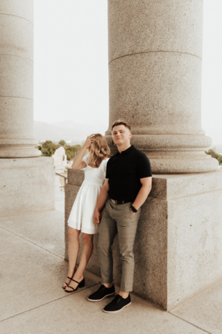 A couple in neutral attire in downtown Dallas Texas kiss and run around for engagement photos. Photography by Hannah Lylene Photography.