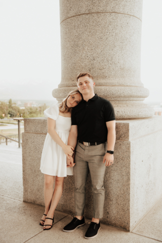 A couple in neutral attire in downtown Dallas Texas kiss and run around for engagement photos. Photography by Hannah Lylene Photography.