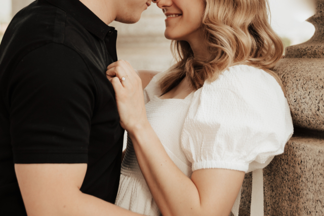 A couple in neutral attire in downtown Dallas Texas kiss and run around for engagement photos. Photography by Hannah Lylene Photography.