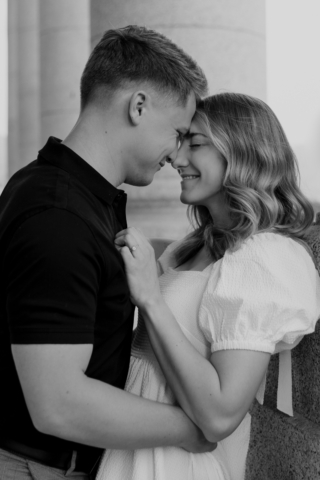 A couple in neutral attire in downtown Dallas Texas kiss and run around for engagement photos. Photography by Hannah Lylene Photography.