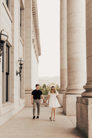 A couple in neutral attire in downtown Dallas Texas kiss and run around for engagement photos. Photography by Hannah Lylene Photography.