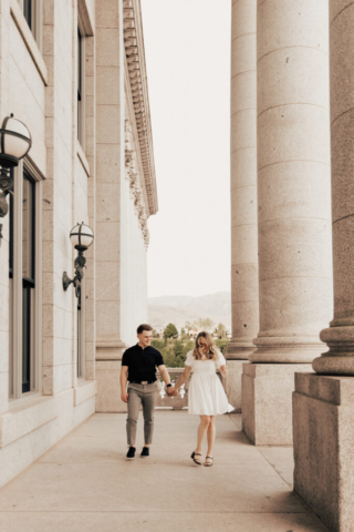 A couple in neutral attire in downtown Dallas Texas kiss and run around for engagement photos. Photography by Hannah Lylene Photography.
