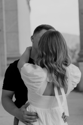 A couple in neutral attire in downtown Dallas Texas kiss and run around for engagement photos. Photography by Hannah Lylene Photography.