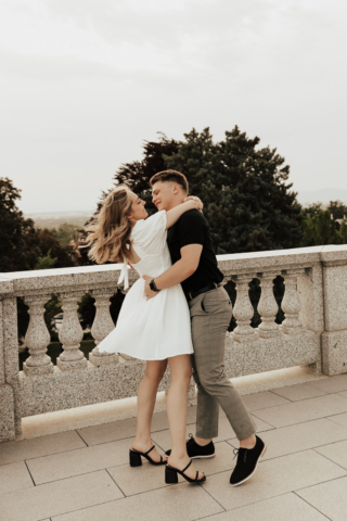 A couple in neutral attire in downtown Dallas Texas kiss and run around for engagement photos. Photography by Hannah Lylene Photography.