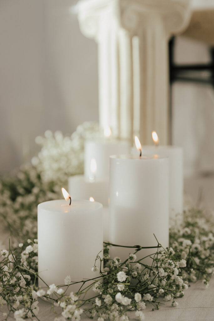Details of an all white proposal set up, with baby&rsquo;s breath and candles at the Lumen Room studio in Fort Worth Texas.