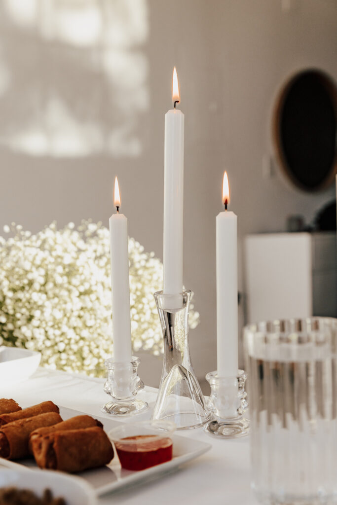 Details of an all white proposal set up, with baby&rsquo;s breath and candles at the Lumen Room studio in Fort Worth Texas.