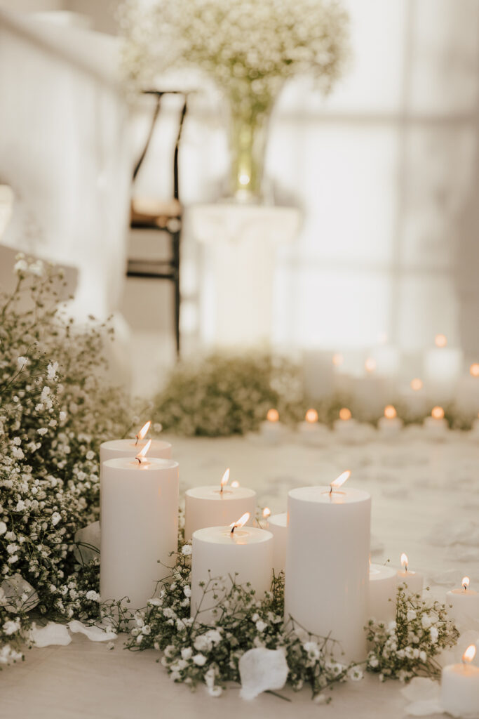 Details of an all white proposal set up, with baby&rsquo;s breath and candles at the Lumen Room studio in Fort Worth Texas.