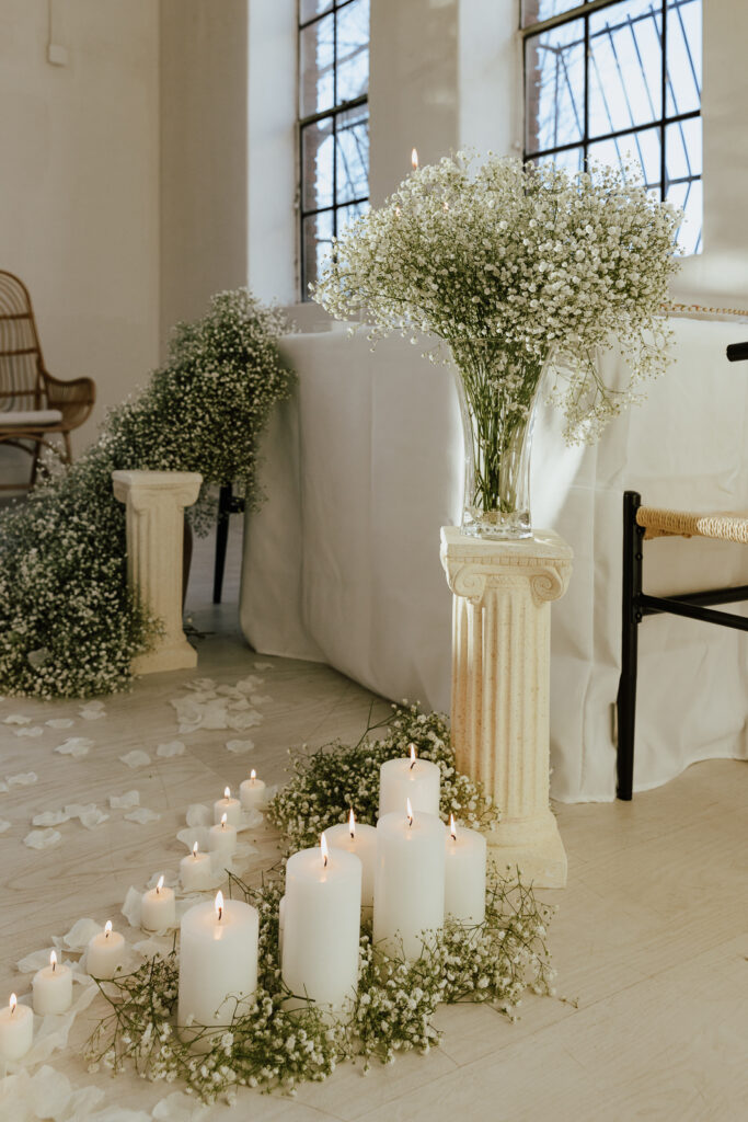 Details of an all white proposal set up, with baby&rsquo;s breath and candles at the Lumen Room studio in Fort Worth Texas.