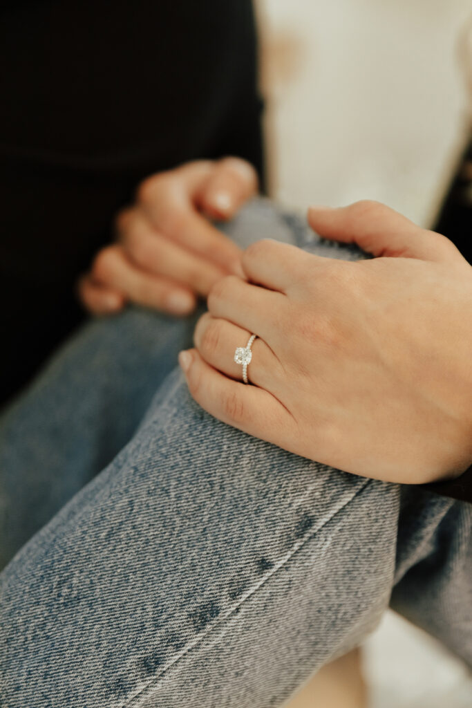 A couple in neutral attire at the Lumen Room Studio in Fort Worth, Texas get engaged surrounded by baby&rsquo;s breath. Photography by Hannah Lylene Photography.