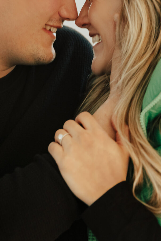 A couple in neutral attire at the Lumen Room Studio in Fort Worth, Texas get engaged surrounded by baby&rsquo;s breath. Photography by Hannah Lylene Photography.