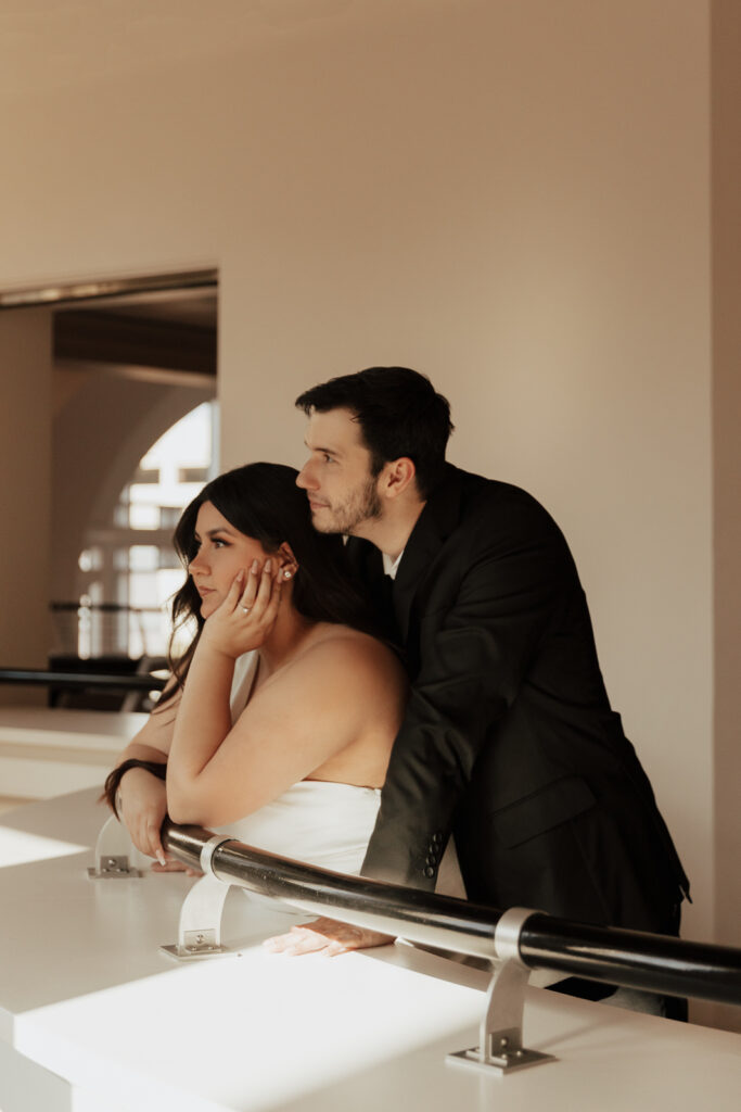 A couple in neutral attire at Bass Hall kiss and run around for engagement photos.