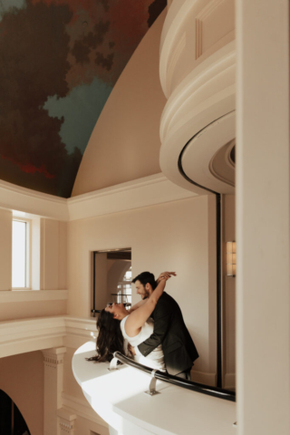 bass-hall-musuem-engagement-fort-worth A couple in neutral attire at Bass Hall kiss and run around for engagement photos.