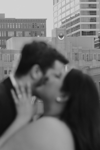 downtown-dfw-elopement-bass-hall A couple in neutral attire at Bass Hall kiss and run around for engagement photos.
