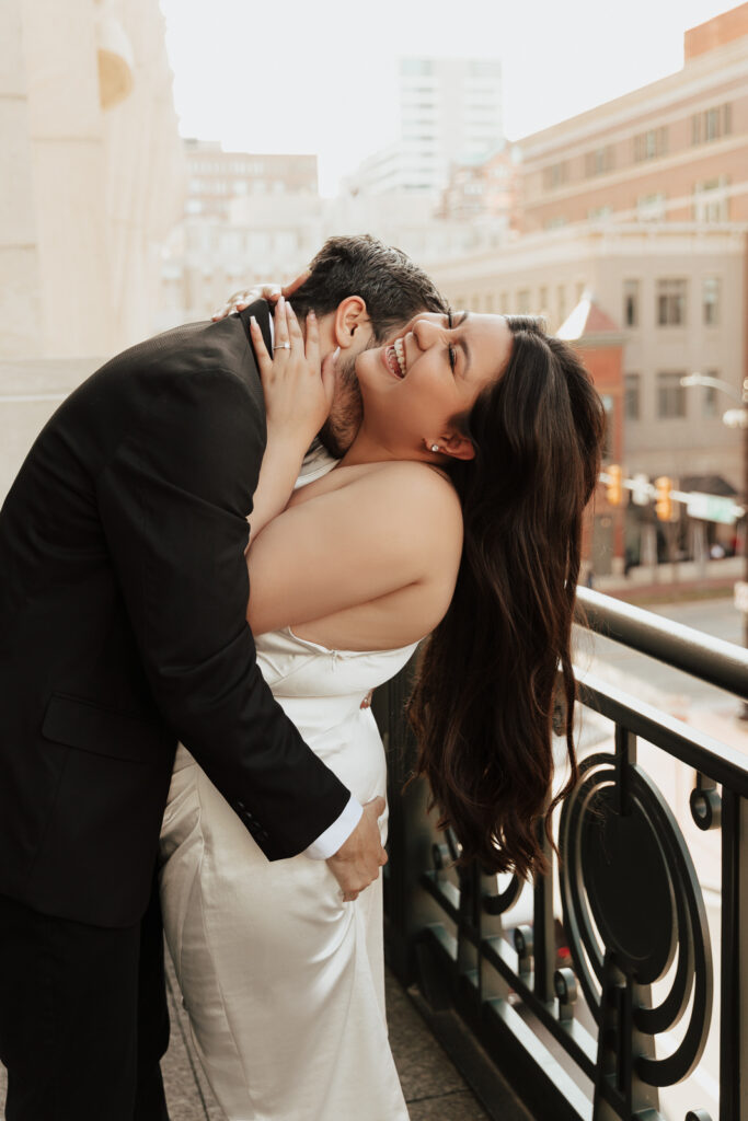 A couple in neutral attire at Bass Hall kiss and run around for engagement photos.