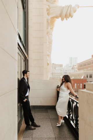 modern-downtown-couples-engagement-texas A couple in neutral attire at Bass Hall kiss and run around for engagement photos.