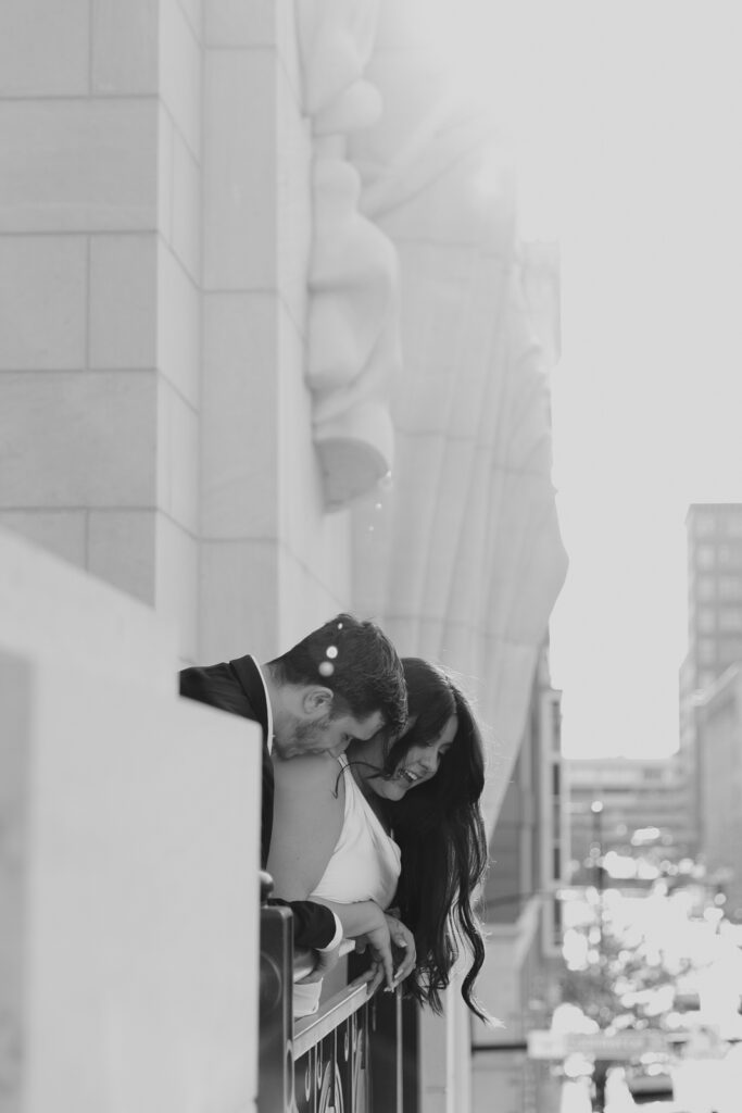 A couple in neutral attire at Bass Hall kiss and run around for engagement photos.