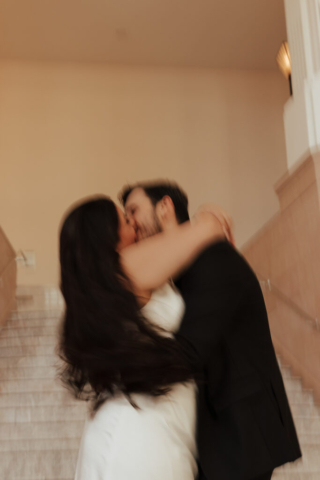 A couple in neutral attire in downtown Dallas Texas kiss and run around for engagement photos. Photography by Hannah Lylene Photography.