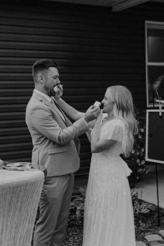 A bride and groom at their Fort Worth Backyard Wedding doing a cake smash