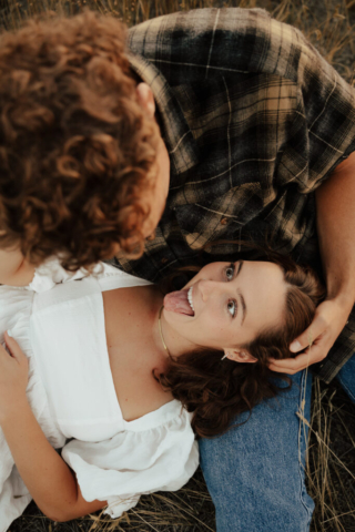 A couple cuddles and makes silly faces during their engagement photos