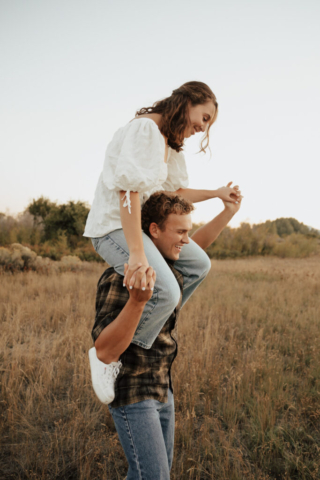A couple in neutral attire in an open field