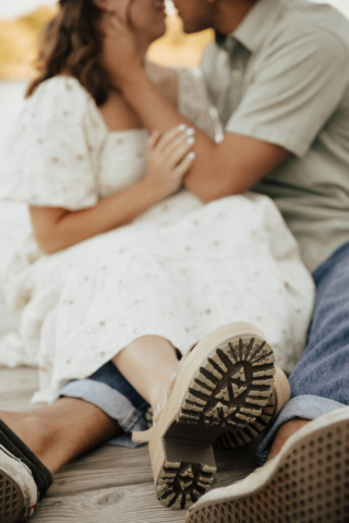 DFW Couple cuddles on a dock by the water
