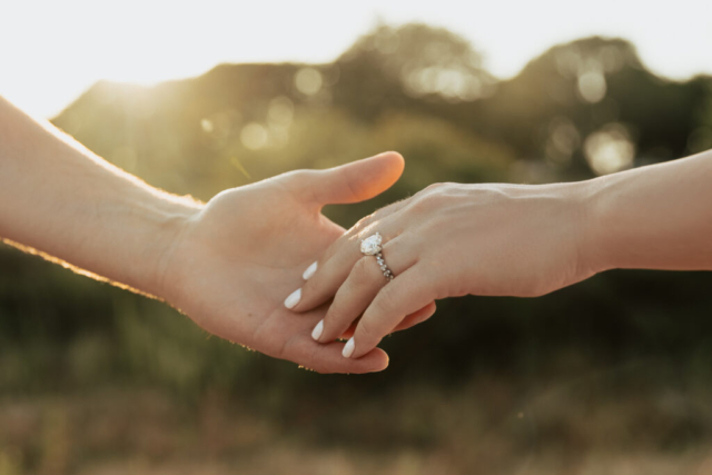 A couple in neutral attire at Grapevine Lake take candid engagement photos.
