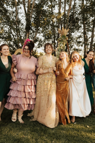 A group of bridesmaids dress in a variety of jewel tone colored mismatched dresses