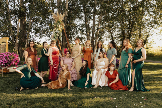 A group of bridesmaids dress in a variety of jewel tone colored mismatched dresses