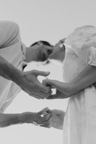A couple in neutral attire at Grapevine Lake take candid engagement photos.