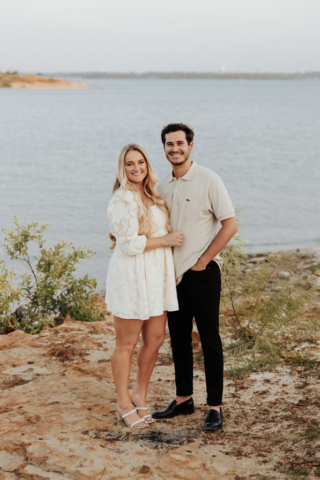 A couple in neutral attire at Grapevine Lake take candid engagement photos.