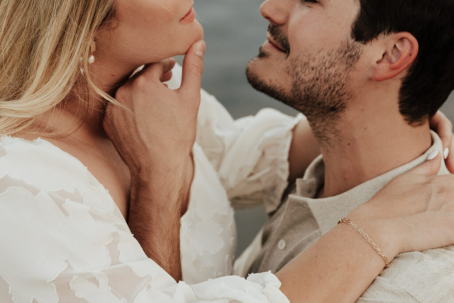 A couple in neutral attire at Grapevine Lake take candid engagement photos.