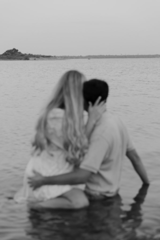 A couple in neutral attire at Grapevine Lake take candid engagement photos.