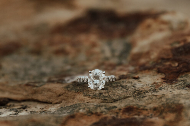 A couple in neutral attire at Grapevine Lake take candid engagement photos.