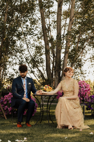 Bride in a golden gown wits with her groom at their backyard Celtic elopement