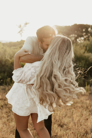 A couple in neutral attire at Grapevine Lake take candid engagement photos.