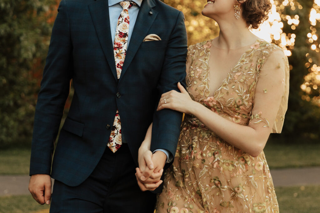 A bride in a gold dress and her groom in a blue suit