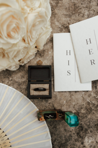 Wedding detail photography of the wedding rings vow books, fan, etc.