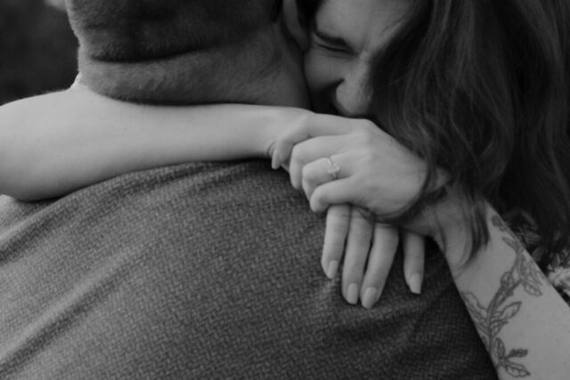 A couple in neutral attire run in an open field take their engagement photos at sunrise by Hannah Lylene Photography.