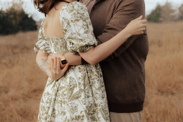 A couple in neutral attire run in an open field take their engagement photos at sunrise by Hannah Lylene Photography.