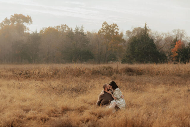 A couple in neutral attire run in an open field take their engagement photos at sunrise by Hannah Lylene Photography.