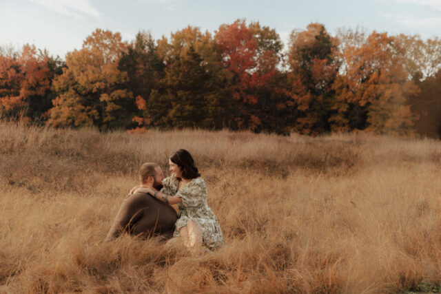 A couple in neutral attire run in an open field take their engagement photos at sunrise by Hannah Lylene Photography.