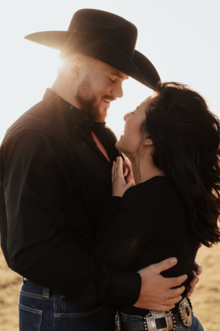 A couple in neutral attire in an open field in Fort Worth, Texas take their documentary style wedding engagement photos.