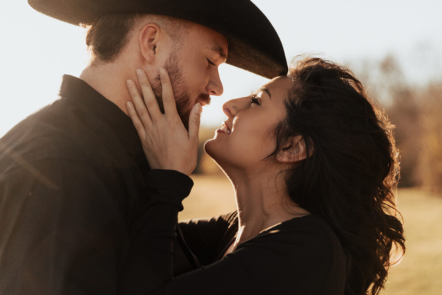 A couple in neutral attire in an open field in Fort Worth, Texas take their documentary style wedding engagement photos.