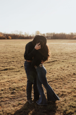 A couple in neutral attire in an open field in Fort Worth, Texas take their documentary style wedding engagement photos.