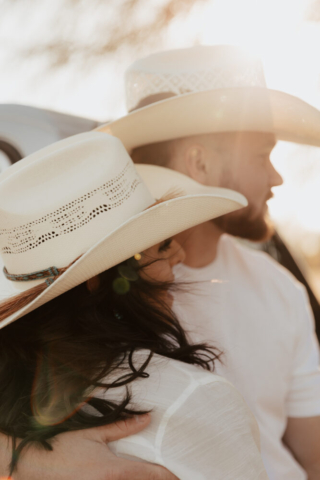 A couple in neutral attire in an open field in Fort Worth, Texas take their documentary style wedding engagement photos.